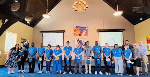 STL Teaching Fellows @ SLU Cohort 5 About 12 program participants wearing matching t-shirts, stand in a row, with faculty members on the side.