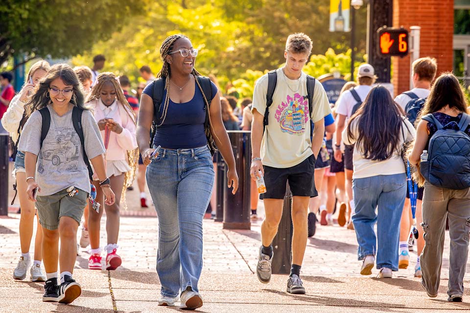 First Day Students cross the street onto campus.