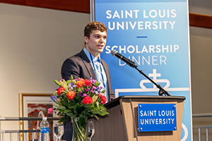 A student speaks to Scholarship Dinner attendees.