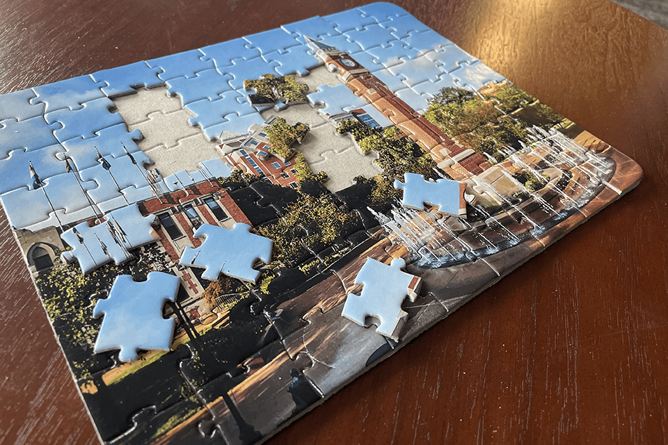 A partially completed puzzle showing SLU's clock tower on a tabletop