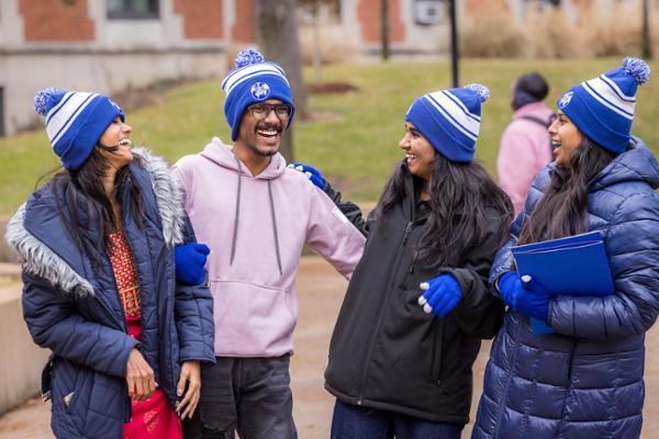 International SLU students in Billiken hats laughing outside in the winter on campus