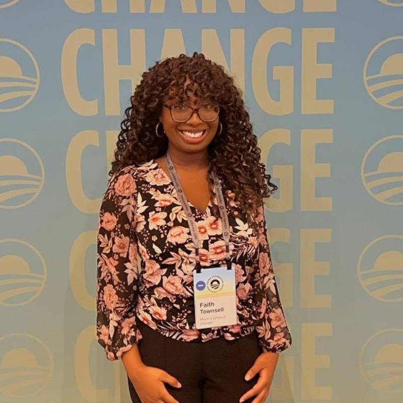 A student stands in front of a banner that reads Change with Barack Obama's logo