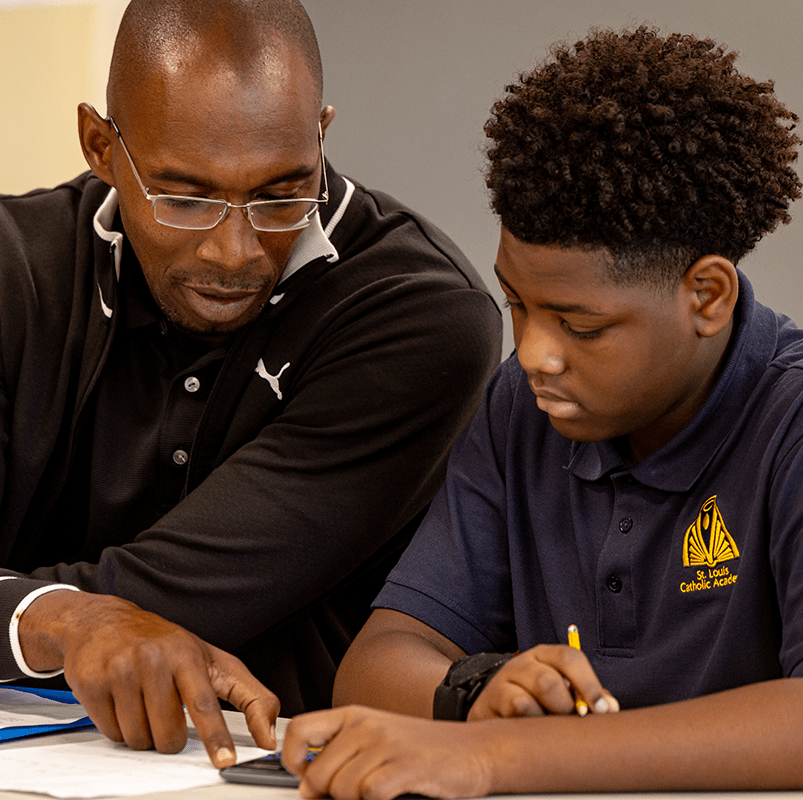 A male education student works with a male middle school student.