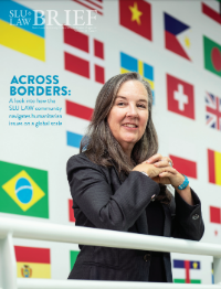 Across Borders: A look into how the SLU LAW community navigates humanitarian issues on a global scale. Photo of Professor Monica Eppinger in front of national flags