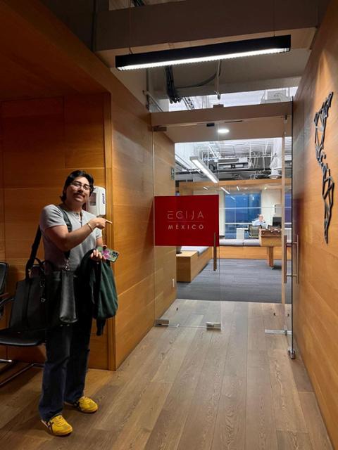 A law student poses for a photo in the hallway of a law firm