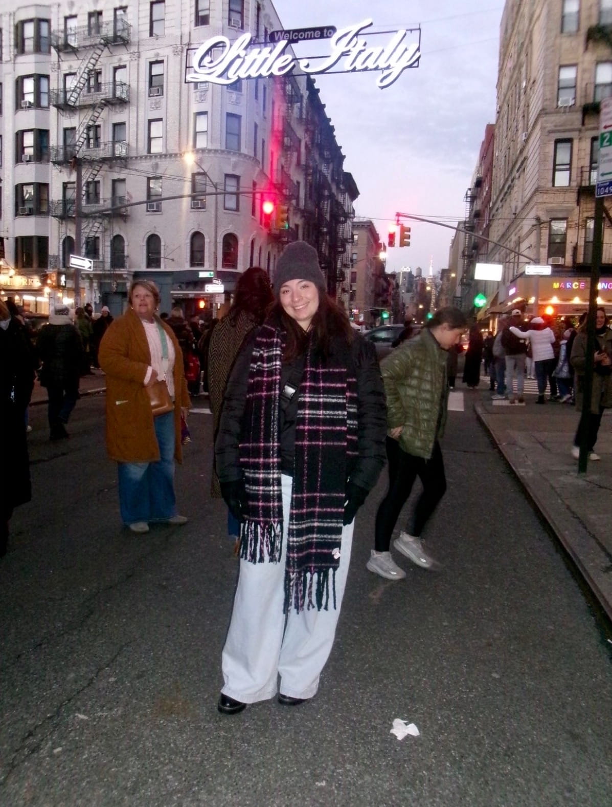 Amelia standing on a crowded street smiling at the camera.