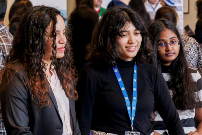 Three students talking to an employer