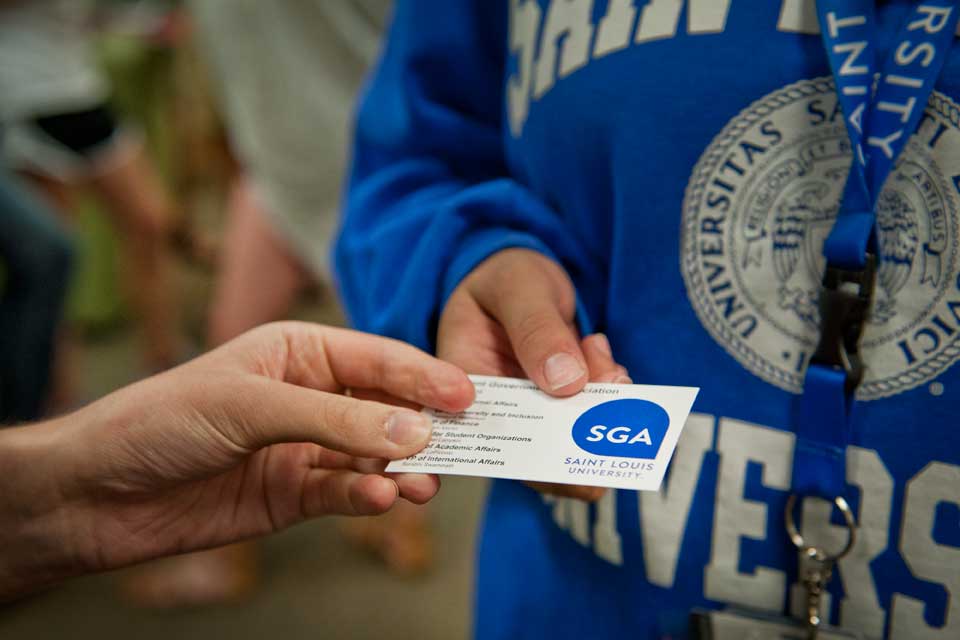 Student holding a SGA business card