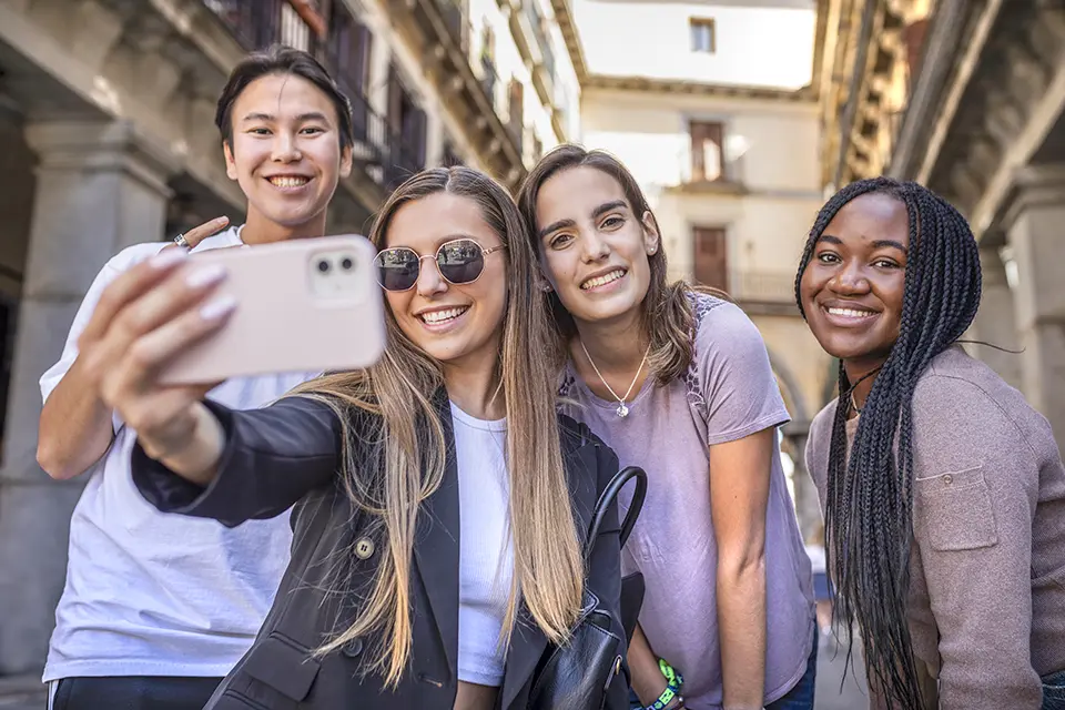 A group of students taking a selfie in the street.