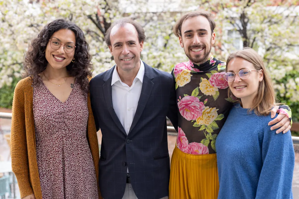 The members of SLU-Madrid counseling team pose for a group photo in front of blossoming trees.