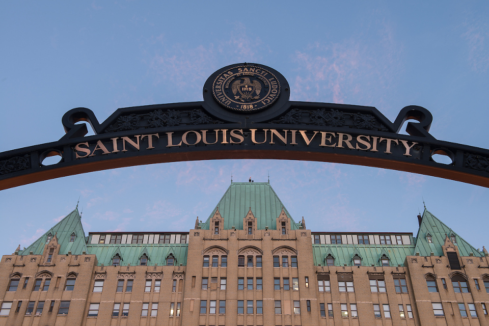 Exterior shot of the SLU School of Medicine building with the Saint Louis University arch in front.