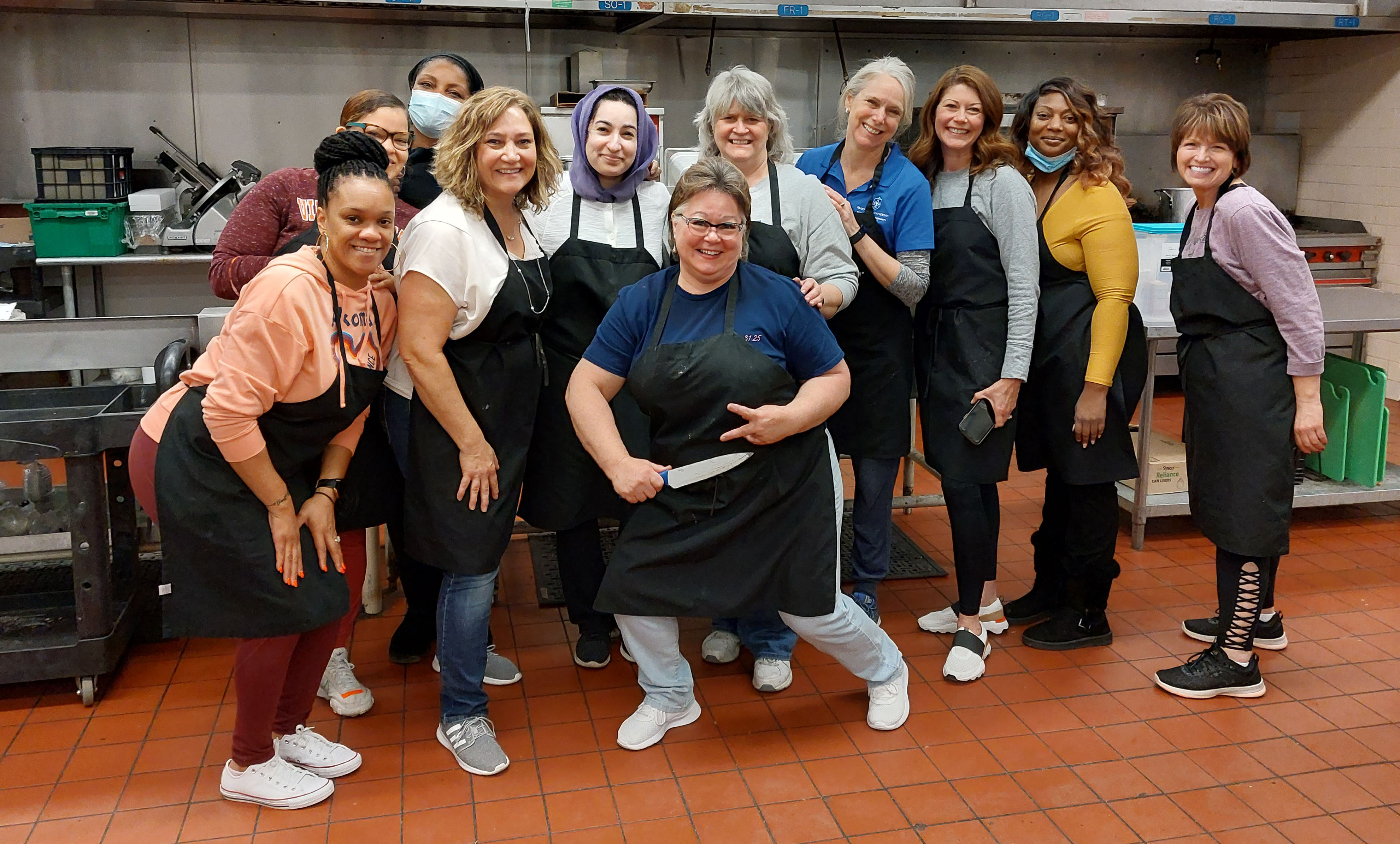 A group of volunteers stand in the kitchen at Campus Kitchen