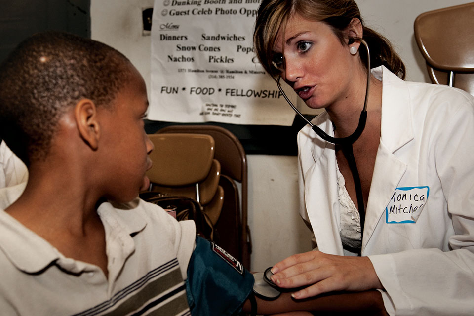 A member of the Community Medicine program takes the blood pressure of a young boy.