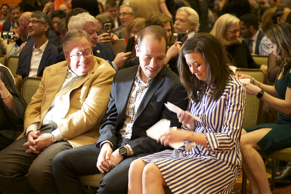 Fourth-year medical student Clare Brady, right, opens her match letter as her boyfriend and her father look on.  Brady matched into family medicine at Northwestern University. Photo by Ellen Hutti.