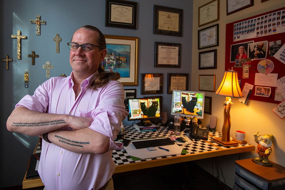 Fred Rottnek standing with arms crossed in front of his desk