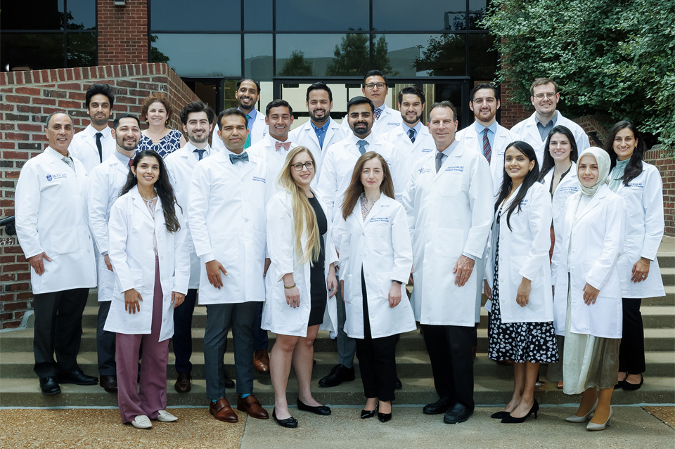A group photo of the Neurology Residents and faculty standing outside in front of a campus building.