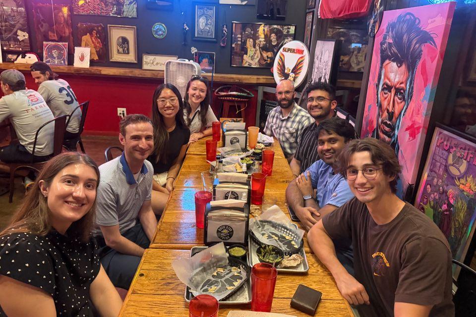 Students and faculty sit around a long table inside a restaurant.