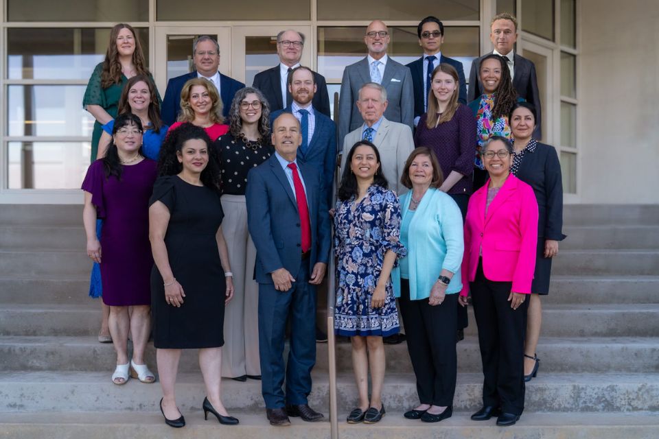 Department of Ophthalmology A group shot of professionally dressed individuals posing on the front steps of an office building.