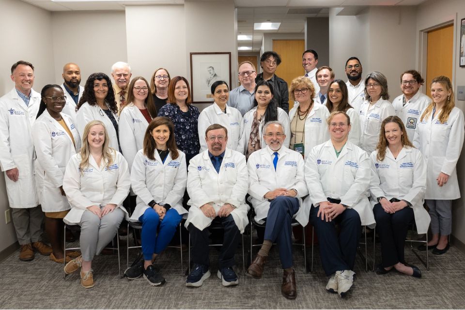 A group photo of psychiatry faculty and staff posing together in an office setting.