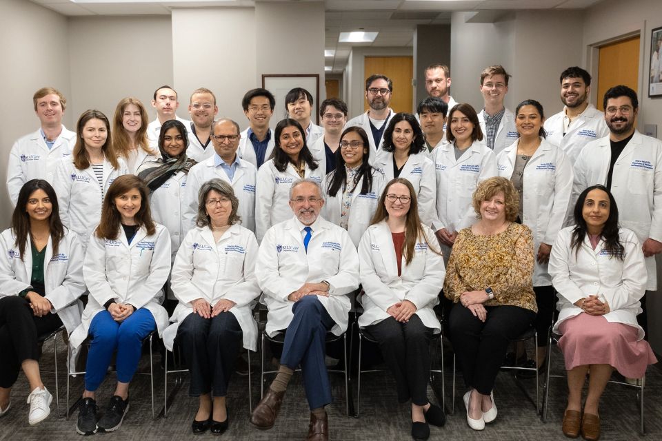A group photo of psychiatry residency faculty, staff and residents posing together in an office setting.