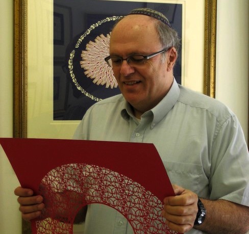 Archie Granot holds one of his papercuts