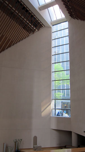 An interior view of St. Peter's Lutheran Church looking down into the sanctuary with street level windows visible to the right.