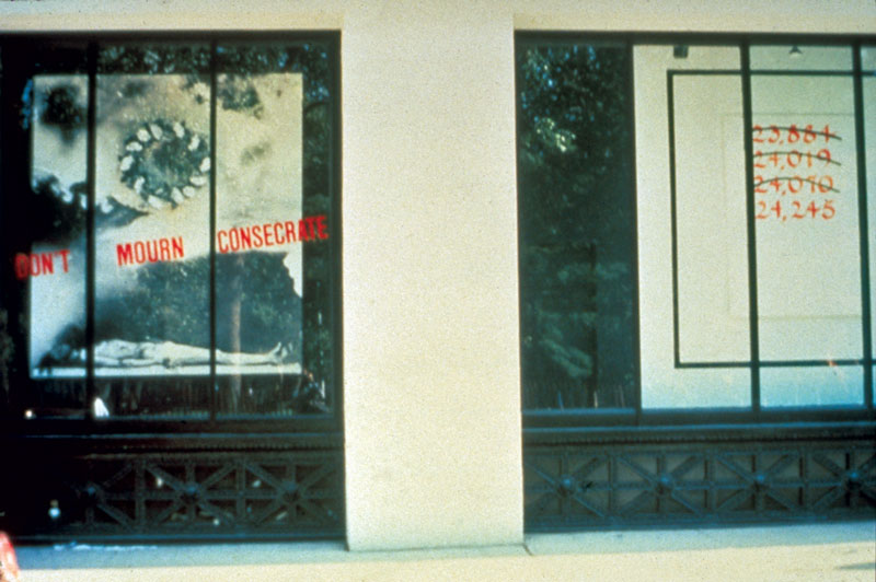 An artwork by Juan González titled Don’t Mourn, Consecrate, shown installed in the street level windows of the Grey Art Gallery at New York University in 1987.