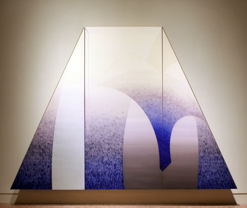 A painting by Daniel Ramirez titled Caelestis Praesepe (Celestial Manger). A large trapezoidal-shaped panting seems to hover off the wall. The abstract imagery includes arcing lines and gentle color gradients in purples and silvers, resulting in a sense of an architectural space like a gothic cathedral.
