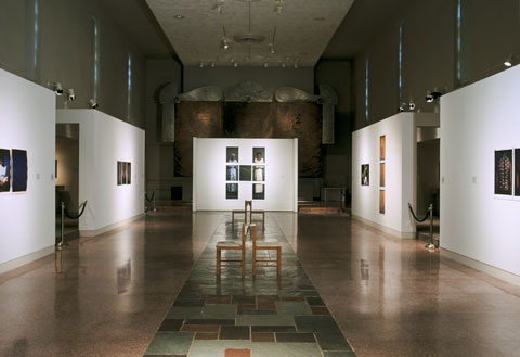 Installation view of the exhibition Rito, Espejo, y Ojo / Ritual, Mirror, and Eye, at MOCRA in 2004. Various photographs by Maria Magdalena Campos-Pons are visible.