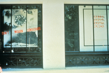 An artwork by Juan Gonzalez titled Don't Mourn, Consecrate, displayed in the streetfront windows of the Gray Art Gallery at New York University in 1987