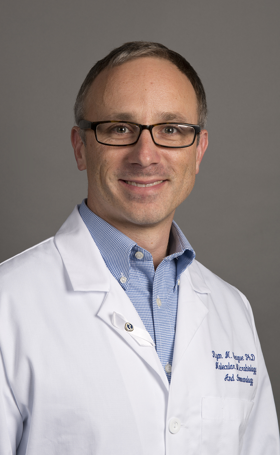 Ryan Teague, Ph.D. A photo of Dr. Ryan Teague wearing a white lab coat.