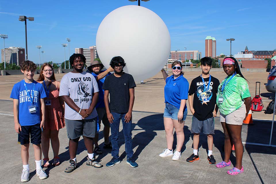 Attendees at the Earth, Wind and Water camp pose for a picture with a weather balloon. One of the events at the camp involved launching weather balloons and studying the data. Photo by Joe Barker.