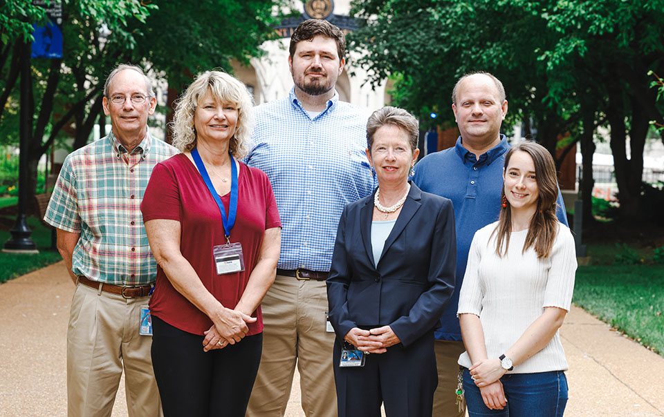 Saint Louis University pain researcher Dr. Daniela Salvemini and her team pose for a photo outdoors during the day. 