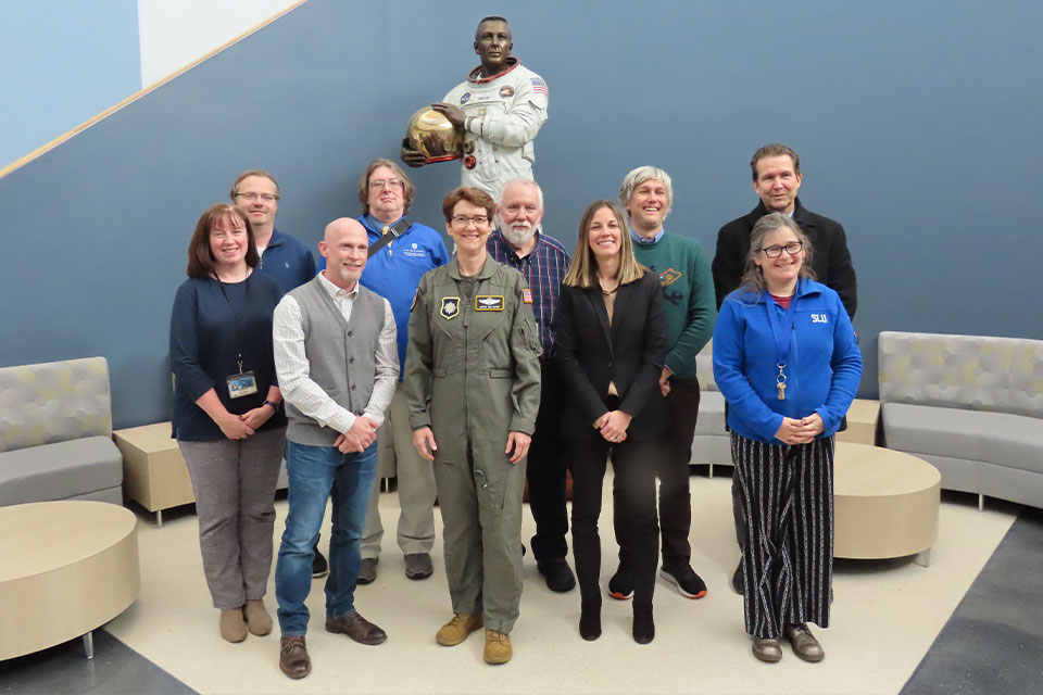 A group poses for a photo with General Jacqueline Van Ovost.