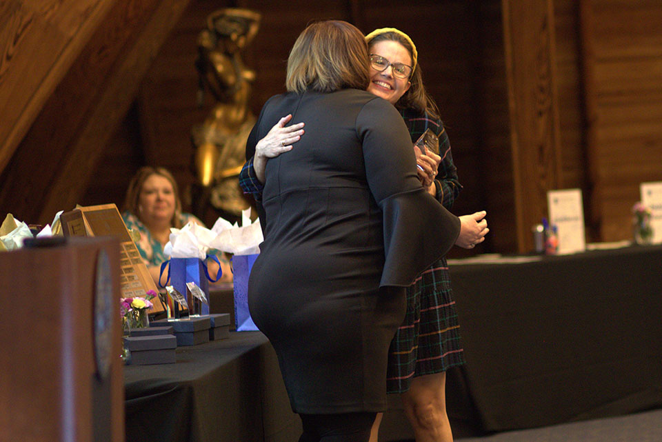 Caitlin Morrell, from Mascoutah High School, accepts the Coordinator Leadership Award from 1818 Director, Beth Collier. 