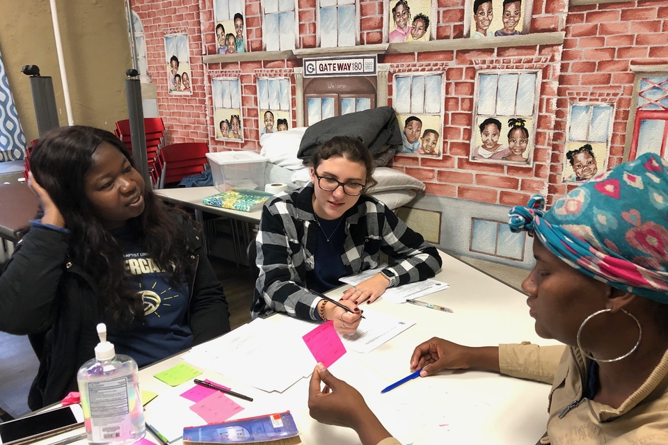 A SLU volunteer works with clients and staff at Gateway 180 as part of a project funded by the University's 1818 Community Grant Program in 2019.