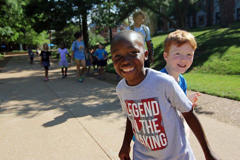 Two kids smile for the camera at a previous Summer at SLU event. 