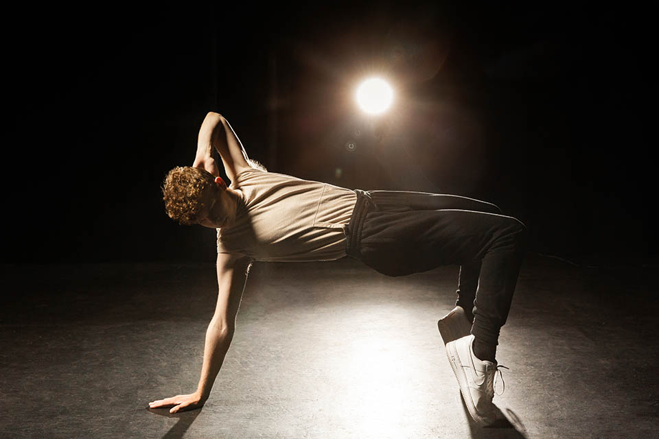 A dance student performs on stage.