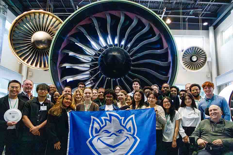 a group of people posing for a photo with a large fan