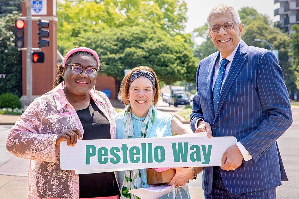 Laura Keys, Ward 11 Alderwoman, First Lady Fran Pestello, Ph.D., and President Fred P. Pestello, Ph.D., pose with a Pestello Way street sign. A portion of Laclede Avenue was renamed on June 10, 2025. Photo by Sarah Conroy.