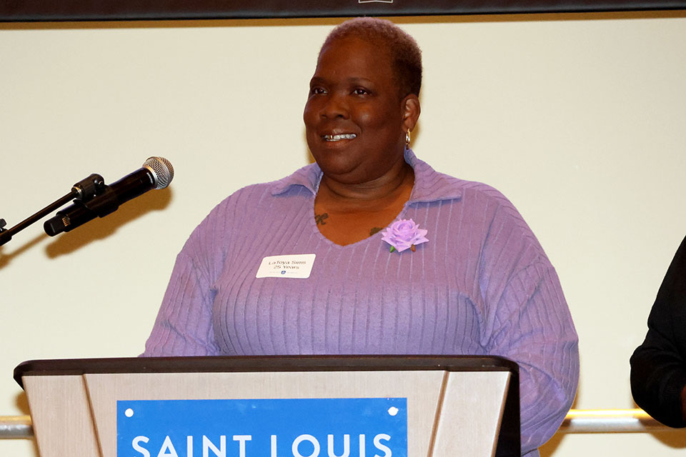 a woman speaks at a podium