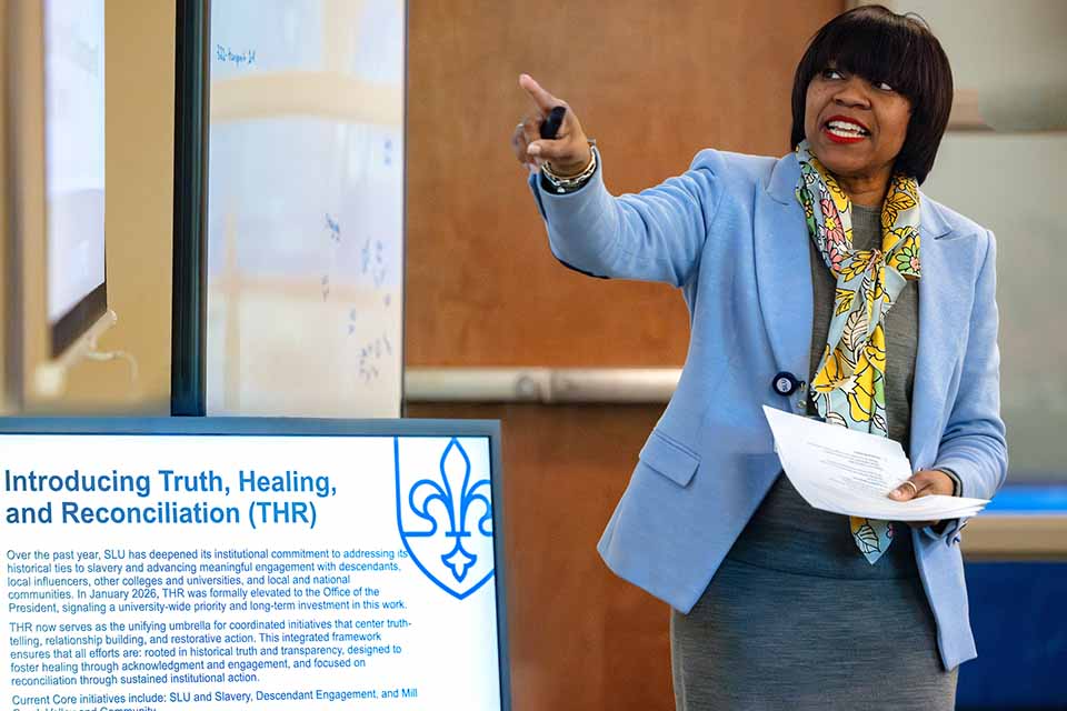 a woman pointing at a screen
