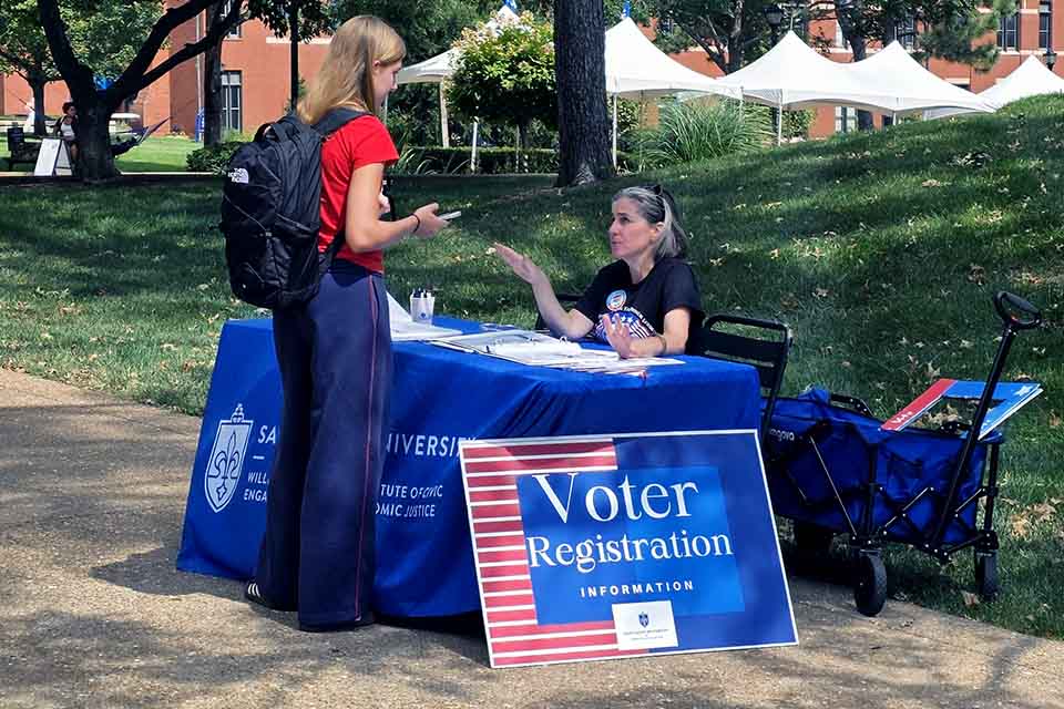 a woman talking to a woman at a table