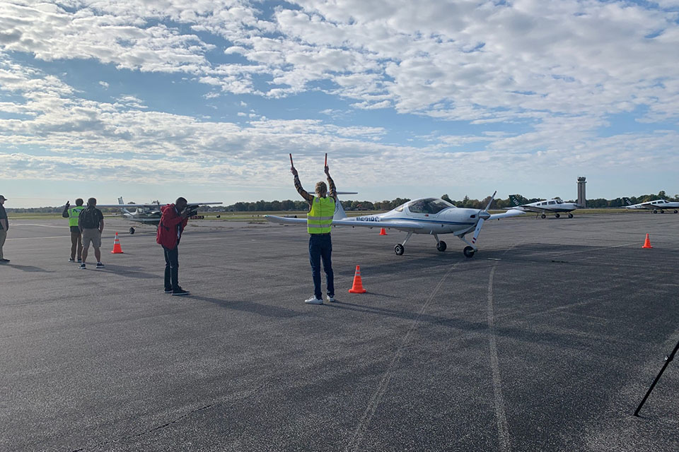 Hudson Pettit, center, assists a Flying Billiken teammate as they land at St. Louis Downtown Airport on Thursday, Oct. 19.  Photo by Maggie Rotermund. 