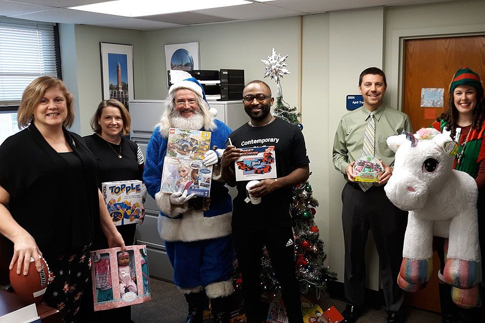 SLU staff and faculty members help Blue Santa carry out his mission to make the holidays bright for local kids by donating toys. Submitted file photo