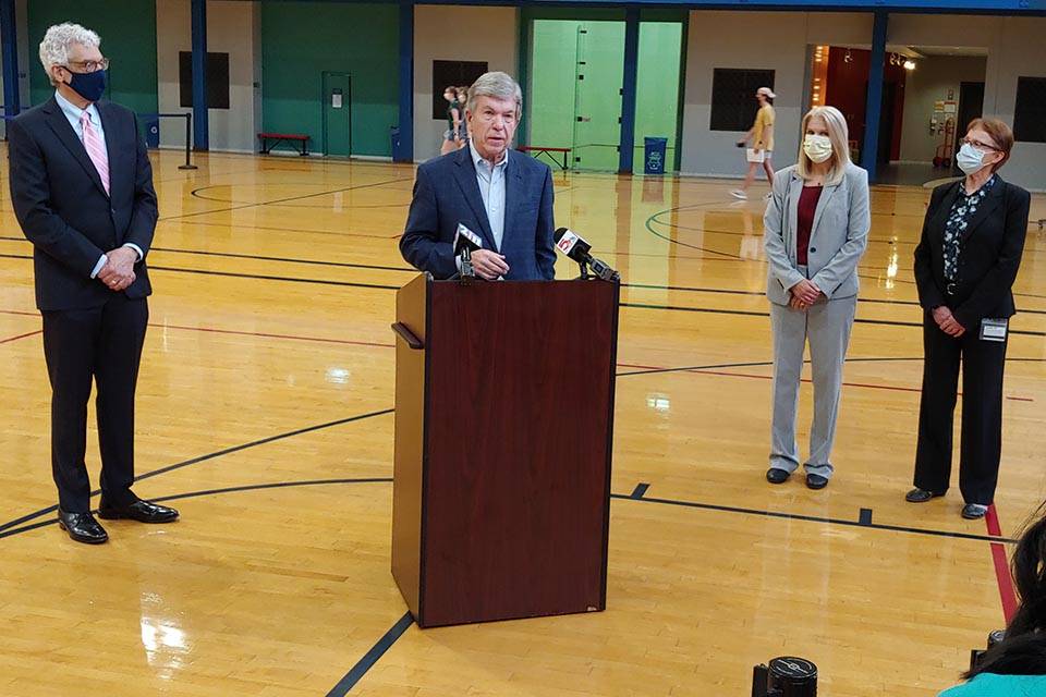 Senator Roy Blunt speaks to reporters next to SLU President Fred P. Pestello, public health expert Terri Rebmann, Ph.D. and vaccine researcher Sharon Frey, M.D.