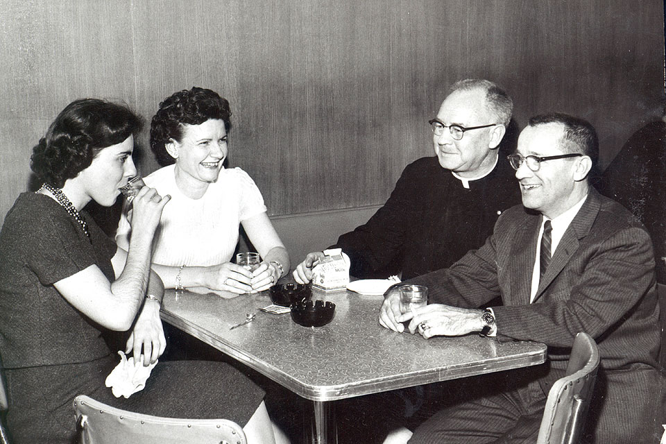 An impromptu "faculty get-together" at the Campus Club after a Billikens basketball game including (seated left to right) Elizabeth Sweeney, assistant director of women's housing; Mary Bruemmer, director of women's housing; Joseph Boland, S.J., assistant professor of religion; and Carroll J. Glenn, executive assistant to the deans of the Institute of Technology. SLU archival photo