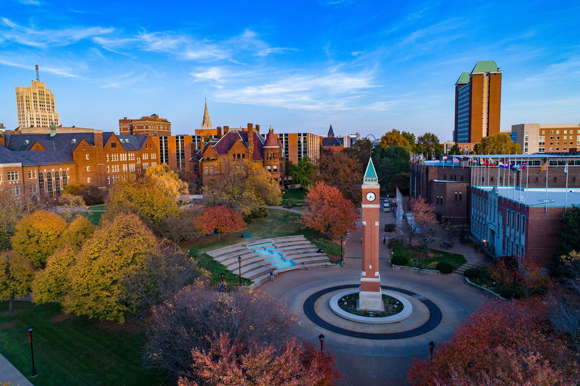 An aerial view of the Clock Tower on the campus of Saint Louis University at twilight in the late view with the Samuel Cupples House and Center for Global Citizenship in the immediate background.