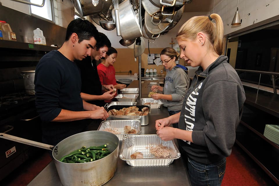 Students make meals in Campus Kitchen during a previous Make a Difference Day