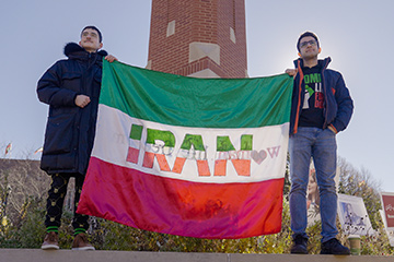 A photo of students holding an Iranian flag at the base of the clock tower during the Campus Rally for Iran.